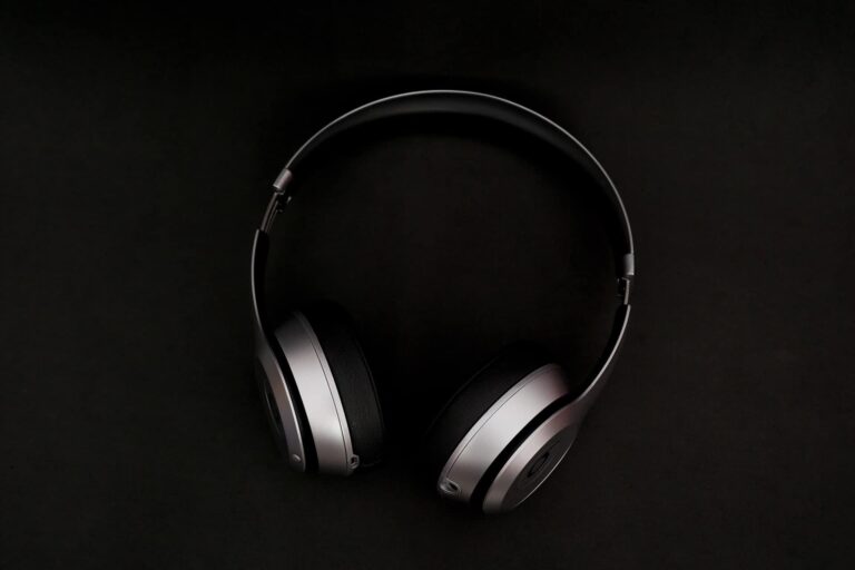 A pair of black and gray over-ear headphones is centered on a dark background. The headphones have a sleek design with cushioned ear pads and a curved headband.