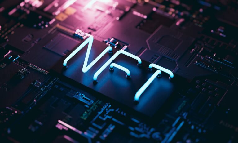 Neon letters "NFT" glow in blue and pink on a dark electronic circuit board background. The image conveys a tech-focused and digital art theme, highlighting the concept of non-fungible tokens.