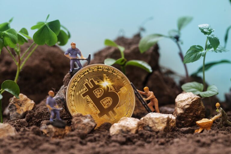 Toy figurines are digging around a large, golden Bitcoin coin surrounded by soil and small plants. This scene symbolizes the concept of "mining" Bitcoin, blending digital currency with natural growth imagery.